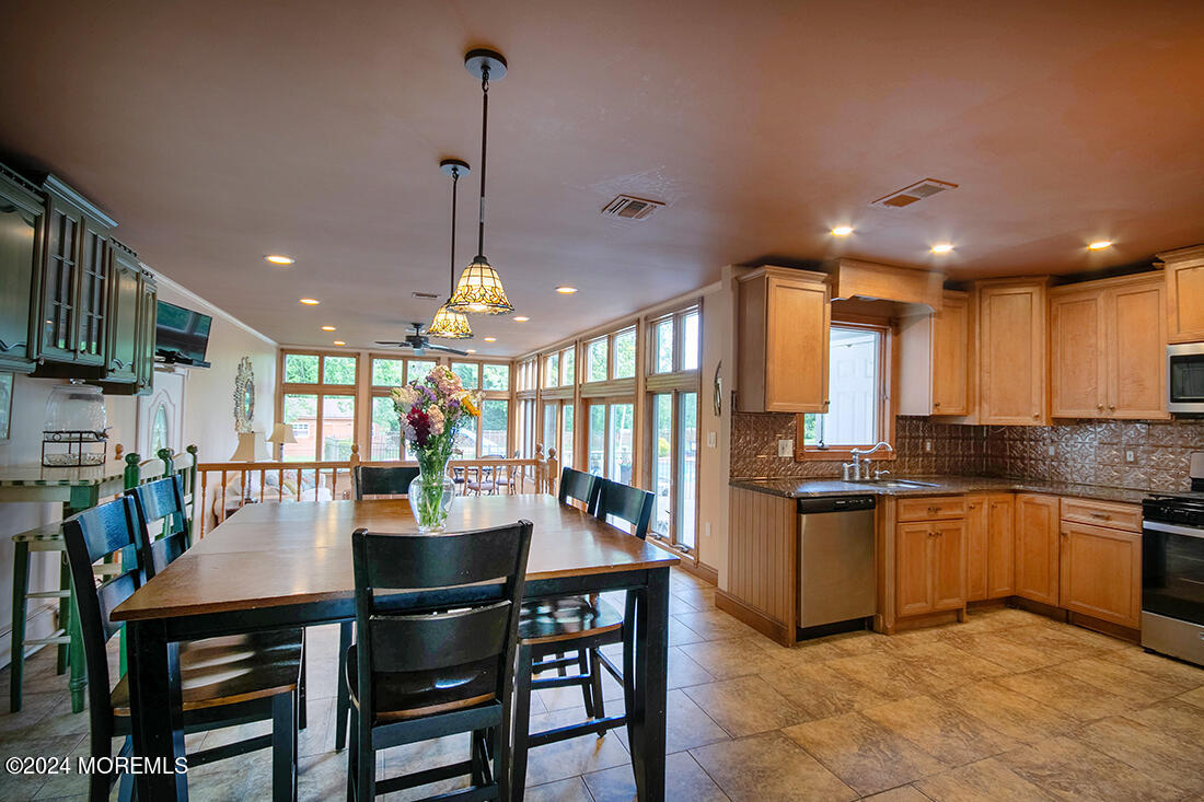 72 Vanderveer Road Freehold, NJ 07728 - Photo 22 of 53 a dining room with stainless steel appliances kitchen island granite countertop a stove a kitchen island a dining table and chairs