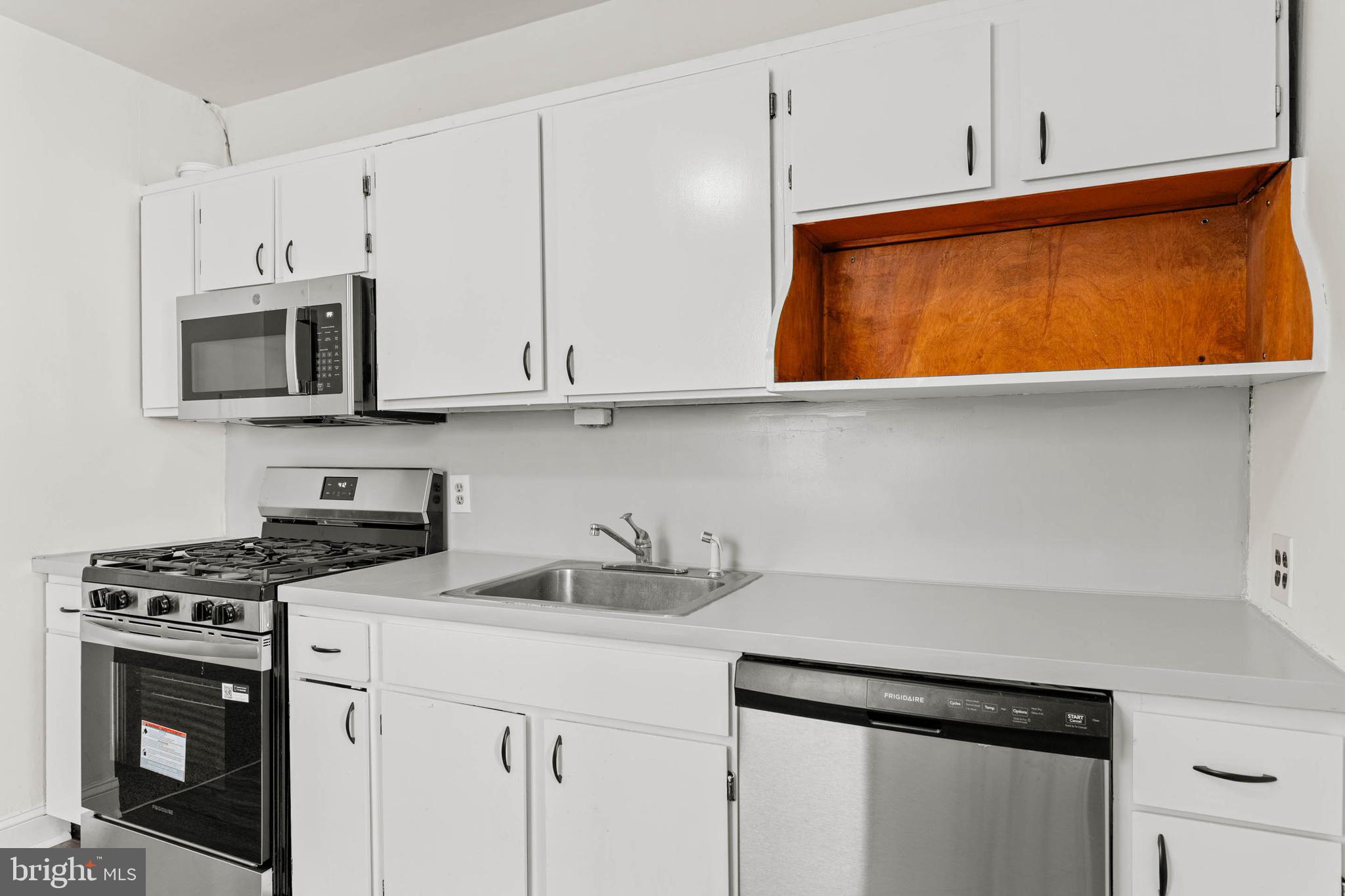 4474 Livingston Street Philadelphia, PA 19137 - Photo 8 of 27 a kitchen with stainless steel appliances a stove a microwave and cabinets
