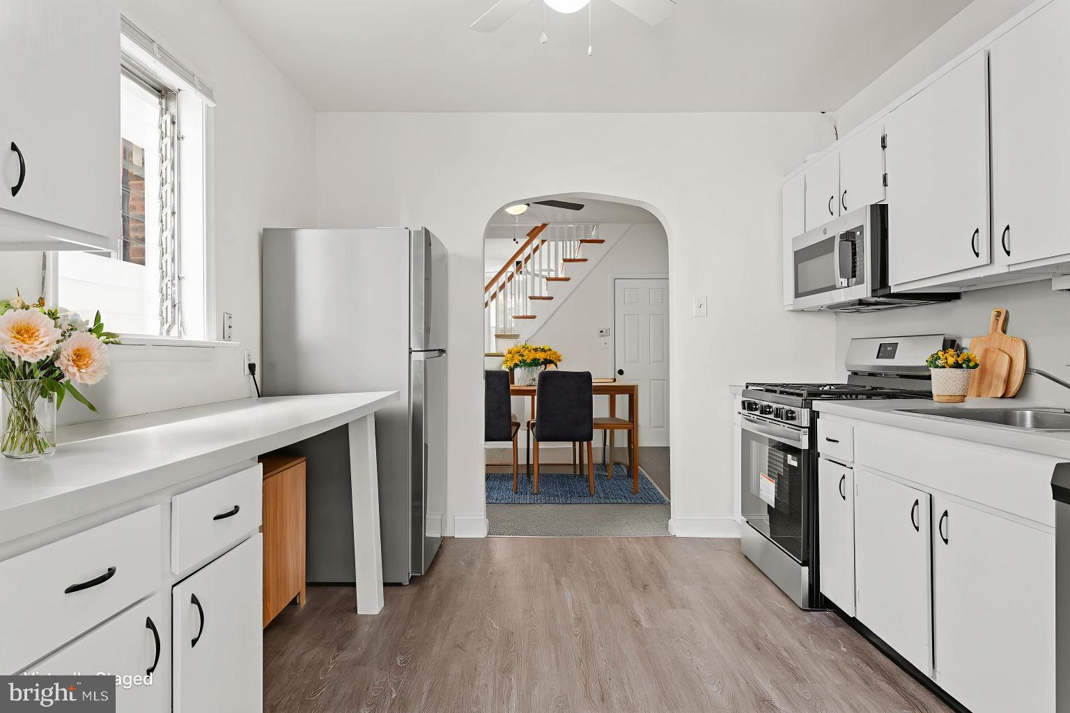 4474 Livingston Street Philadelphia, PA 19137 - Photo 9 of 27 a kitchen with stainless steel appliances granite countertop a refrigerator a sink dishwasher and white cabinets with wooden floor