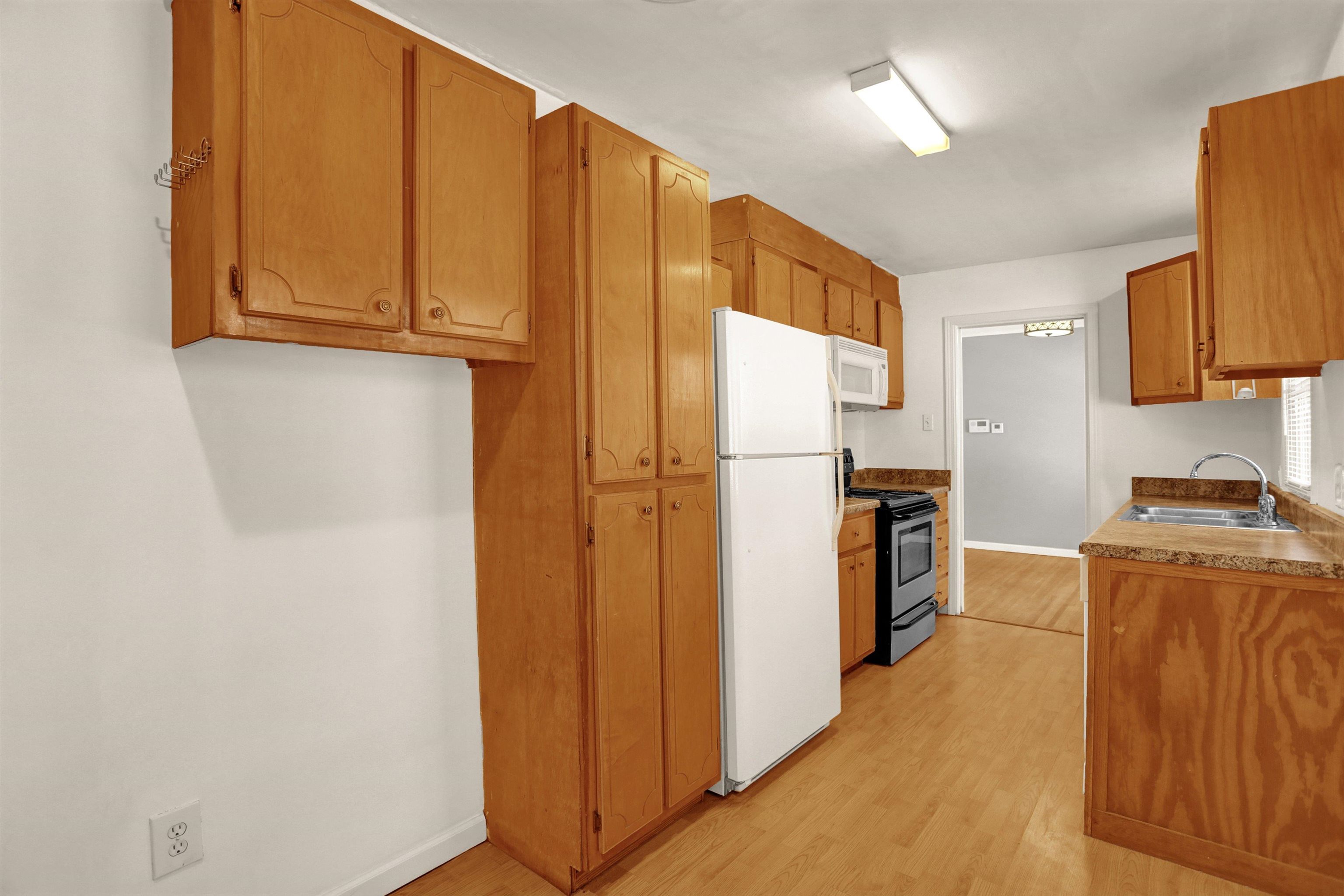 1459 Flamingo Road Memphis, TN 38117 - Photo 27 of 31 a kitchen with stainless steel appliances granite countertop a refrigerator a stove and a sink with wooden floor