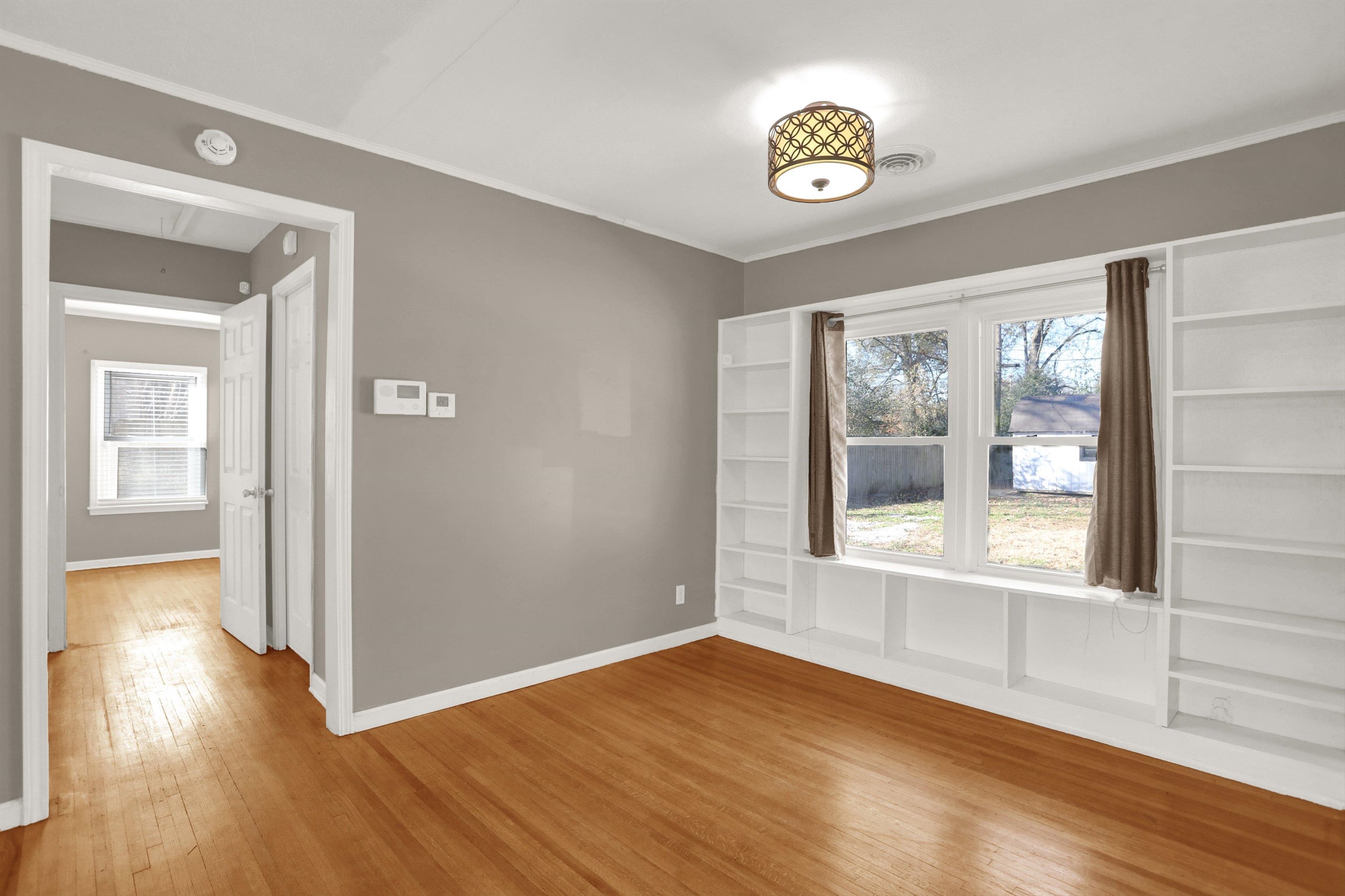 1459 Flamingo Road Memphis, TN 38117 - Photo 7 of 31 a view of an empty room with wooden floor and a window