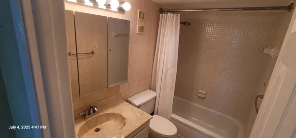 a bathroom with a sink toilet and shower