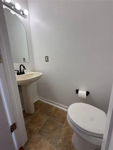 a bathroom with a sink a toilet and mirror
