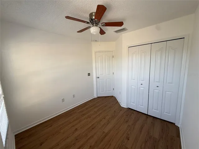 a view of room with hardwood floor and a ceiling fan
