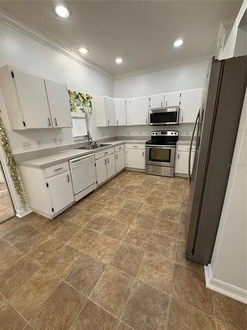 a kitchen with stainless steel appliances a refrigerator sink and microwave