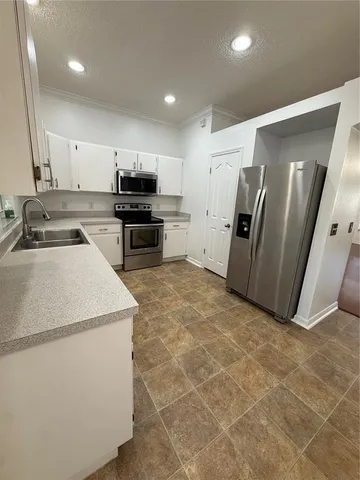a kitchen with a sink and stainless steel appliances