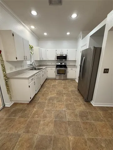 a kitchen with stainless steel appliances a refrigerator sink and cabinets