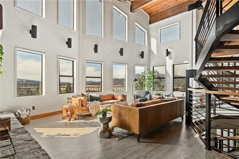 a living room with fireplace furniture and a large window