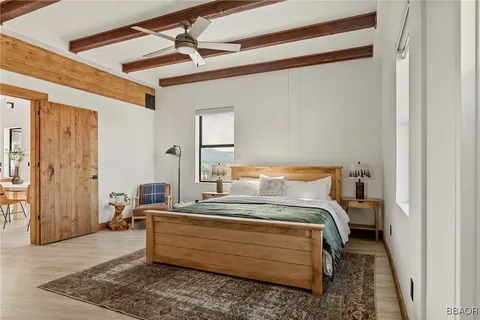 a bedroom with a bed and wooden floor