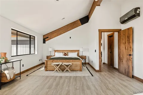 a bedroom with a bed and wooden floor