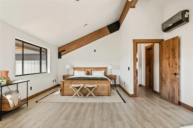 a bedroom with a bed and wooden floor