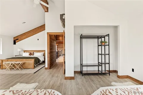 a view of a bedroom with wooden floor and furniture