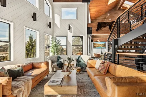 a living room with furniture a rug and a large window