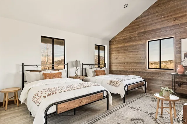 a bedroom with a bed and large windows