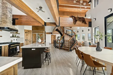 a kitchen with stainless steel appliances kitchen island granite countertop a table chairs in it and wooden floors