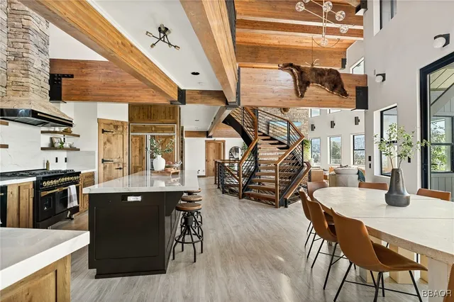 a kitchen with stainless steel appliances kitchen island granite countertop a table chairs in it and wooden floors