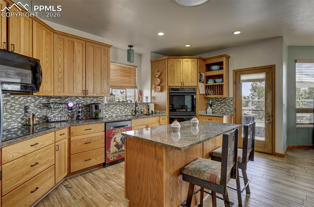 5910 McCart Ranch Circle Elizabeth, CO 80107 - Photo 7 of 50 a kitchen with stainless steel appliances granite countertop a kitchen island hardwood floor sink stove and granite counter top
