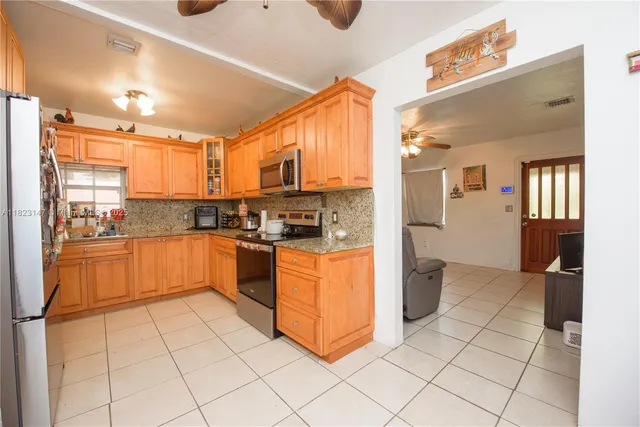 a kitchen with stainless steel appliances a refrigerator sink and cabinets