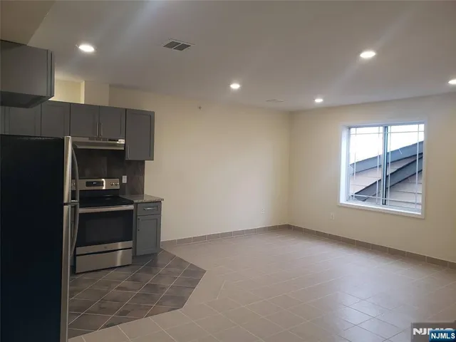 a kitchen with granite countertop a stove and a refrigerator