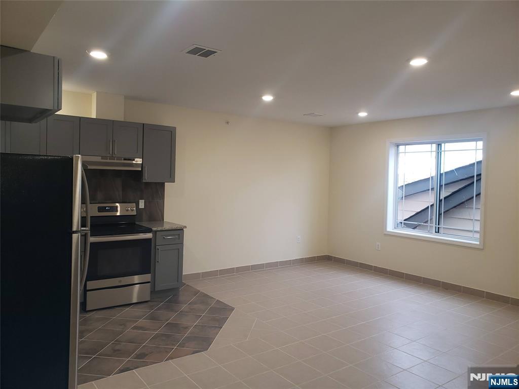 44 Bergen Boulevard, Unit 9 Fairview, NJ 07022 - Photo 6 of 16 a kitchen with granite countertop a stove and a refrigerator