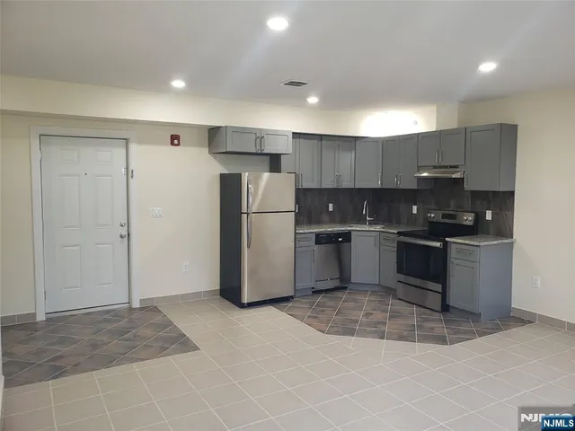a kitchen with stainless steel appliances granite countertop a refrigerator sink and cabinets