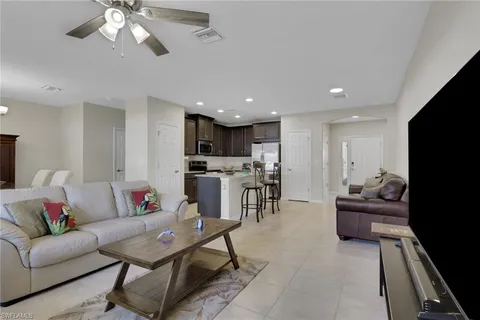 a living room with furniture and kitchen view