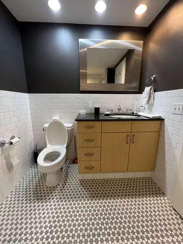 a bathroom with a toilet a sink and mirror