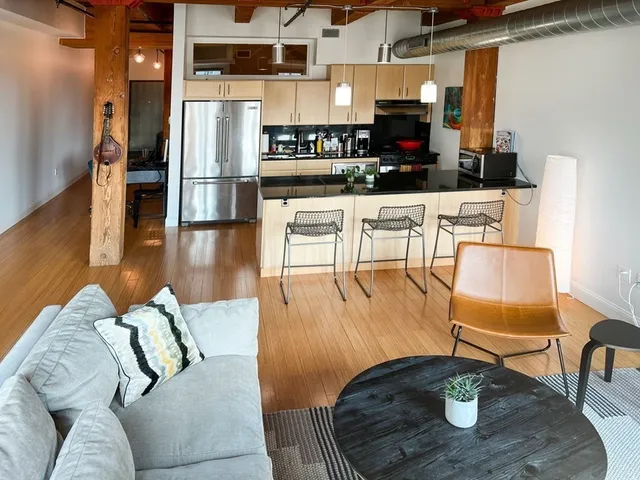 a living room with furniture and a wooden floor