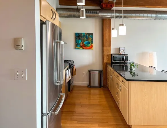 a kitchen with stainless steel appliances granite countertop a refrigerator and a stove