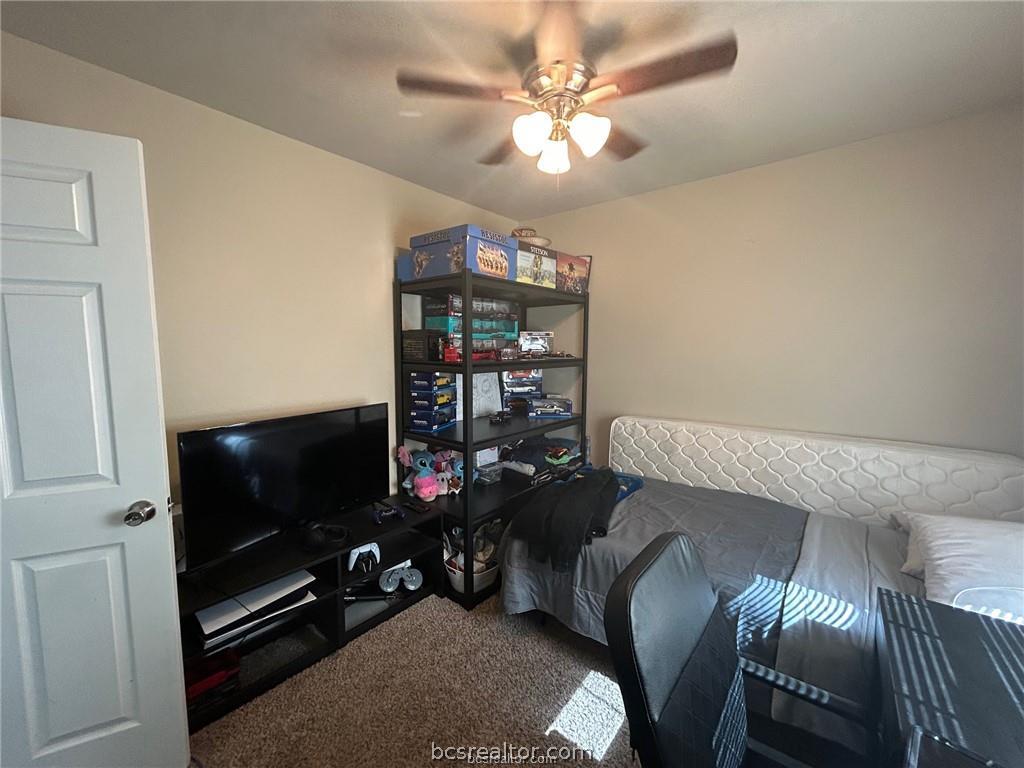 305 Ehlinger Drive, Unit D Bryan, TX 77801 - Photo 7 of 11 a living room with furniture a flat screen tv and a bookshelf
