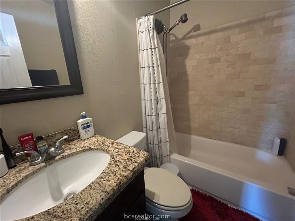 305 Ehlinger Drive, Unit D Bryan, TX 77801 - Photo 8 of 11 a bathroom with a granite countertop sink toilet and shower