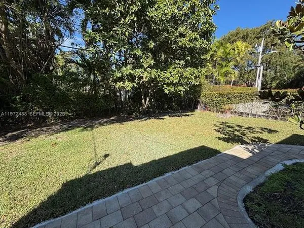 a view of a yard with wooden fence