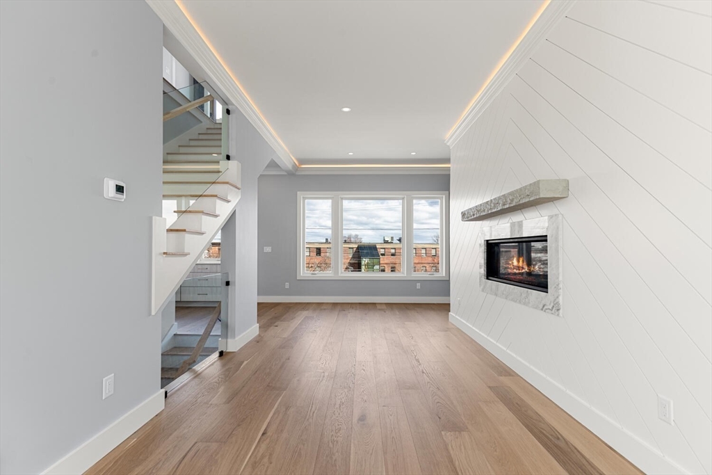 308 Newton Street, Unit 1F Waltham, MA 02453 - Photo 18 of 37 a view of a hallway with wooden floor and a fireplace