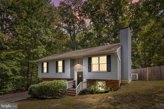 a front view of a house with yard and trees