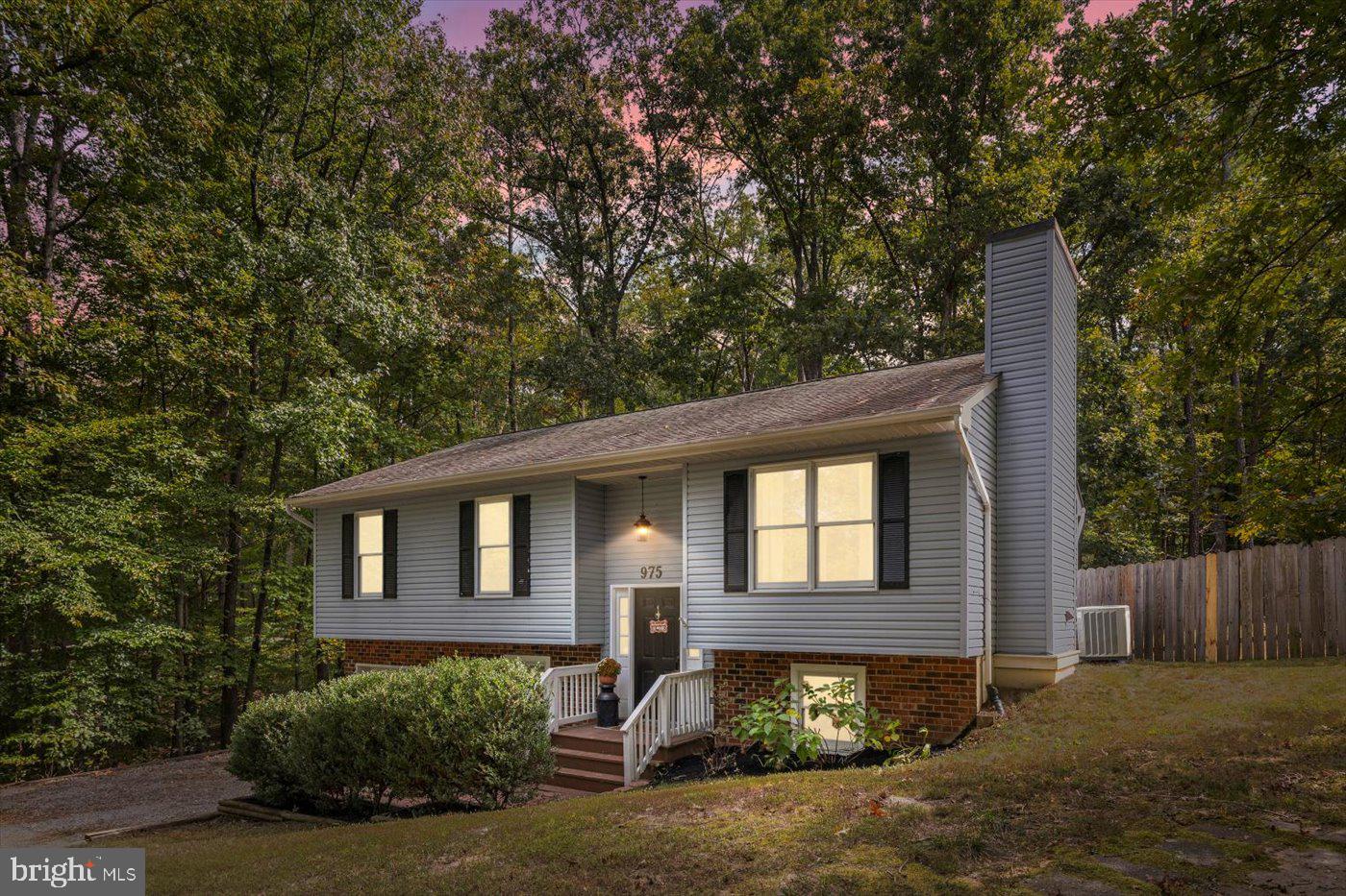 a front view of a house with yard and trees