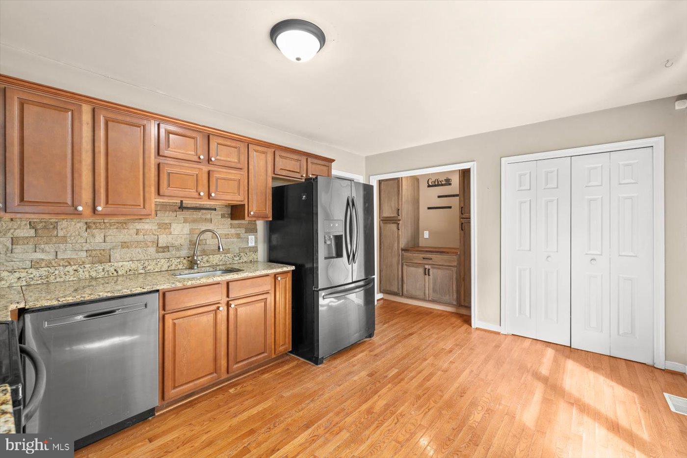 975 Swan Lane Ruther Glen, VA 22546 - Photo 14 of 42 a kitchen with stainless steel appliances granite countertop a refrigerator a sink dishwasher a stove with wooden cabinets and floor