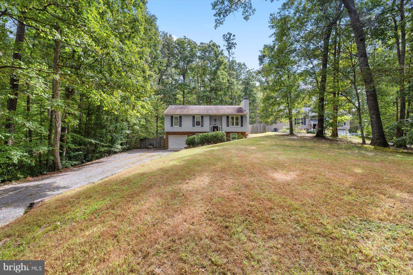 975 Swan Lane Ruther Glen, VA 22546 - Photo 2 of 42 a view of an house with backyard and trees