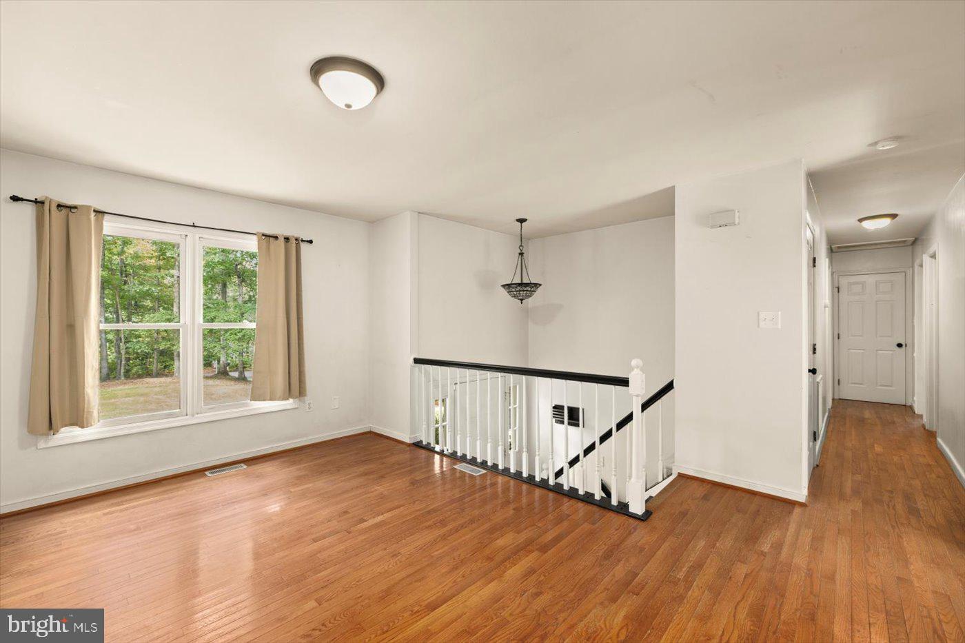 975 Swan Lane Ruther Glen, VA 22546 - Photo 7 of 42 an empty room with wooden floor and windows