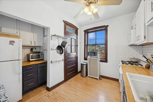 a kitchen with stainless steel appliances granite countertop a refrigerator a stove a sink dishwasher and a refrigerator with wooden floor