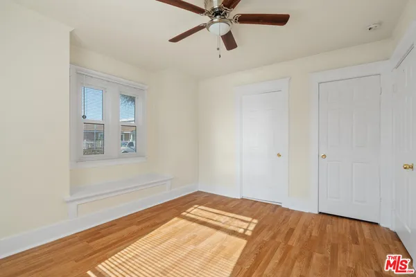 a view of a bedroom with a bed and wooden floor