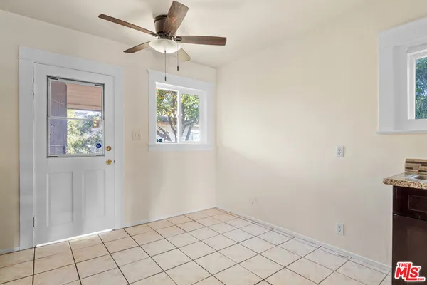 an empty room with windows and fan