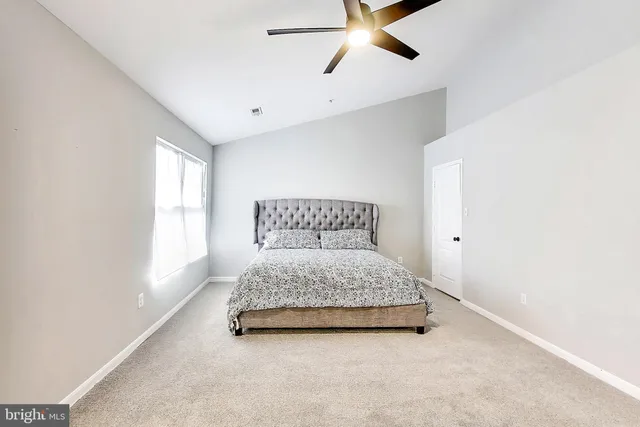 a spacious bedroom with a bed and window