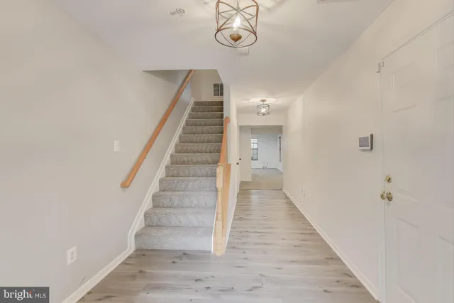 a view of a hallway with wooden floor and staircase
