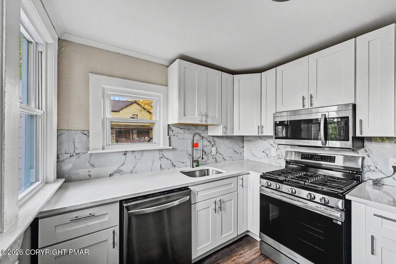 432 Edwards Court Scranton, PA 18504 - Photo 14 of 34 a kitchen with stainless steel appliances white cabinets and a stove top oven