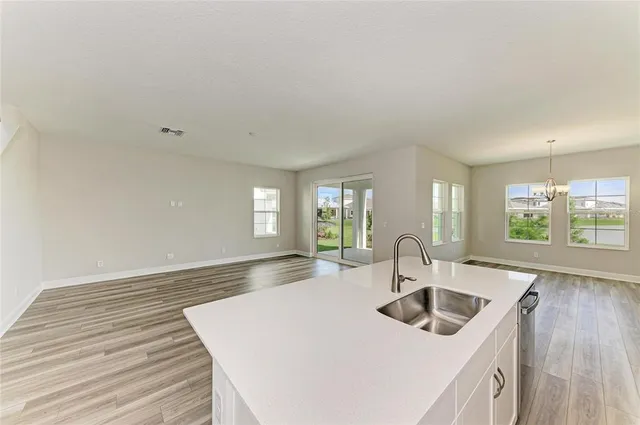 a kitchen with sink and view of living room