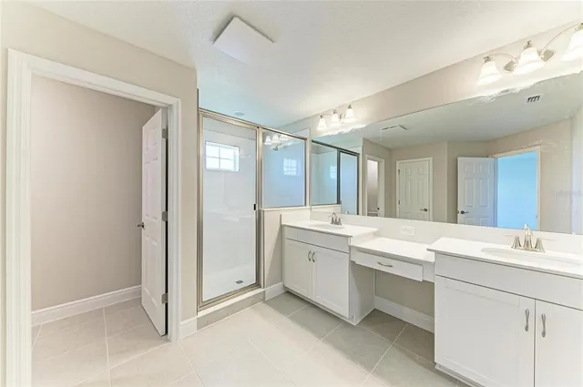 a view of a double vanity sink mirror and cabinets
