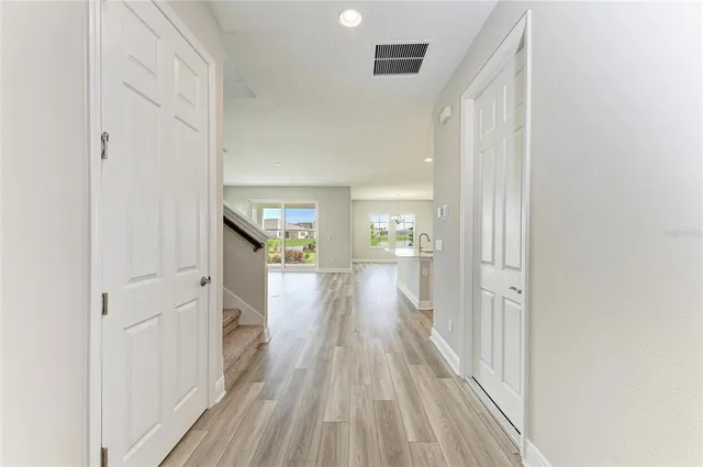 a view of a hallway with wooden floor and staircase