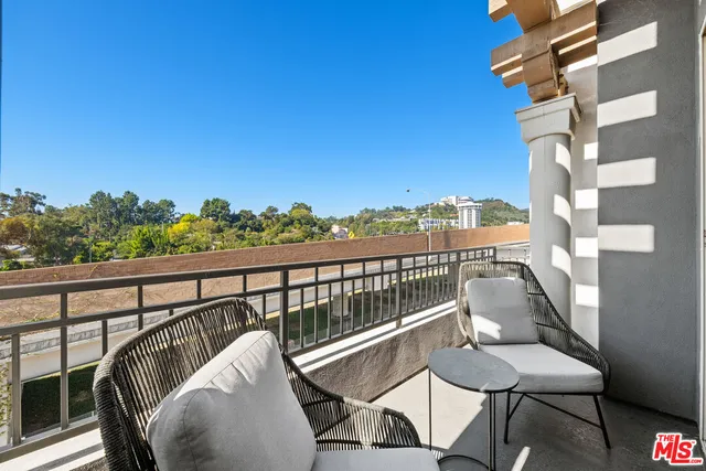 a bedroom with a balcony a bed and a large window