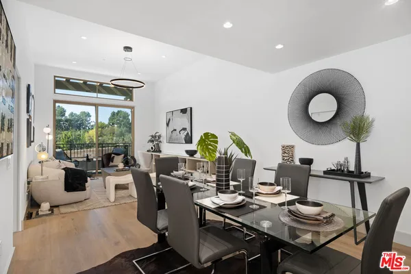 a living room with furniture a rug and a floor to ceiling window