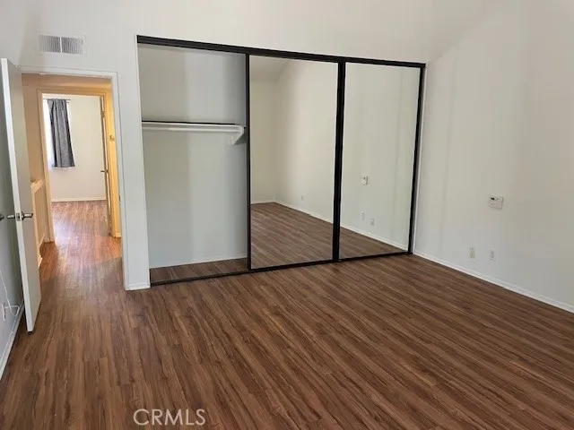 a view of empty room with wooden floor and cabinet